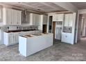 Spacious kitchen featuring white cabinetry, a large island, and modern layout, perfect for culinary enthusiasts at 13308 Chopin Ridge Rd, Huntersville, NC 28078