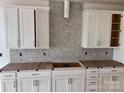 Bright kitchen featuring white cabinets with modern hardware and patterned tile backsplash at 13308 Chopin Ridge Rd, Huntersville, NC 28078