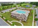 Aerial view of community pool and clubhouse with ample seating, parking, and green spaces at 13744 Roderick Dr # 173, Huntersville, NC 28078