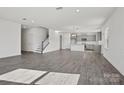 Open-concept living space with gray wood floors, a staircase, and a kitchen with gray cabinets at 13744 Roderick Dr # 173, Huntersville, NC 28078