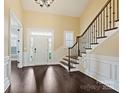 The open foyer features hardwood floors, a staircase with decorative iron railings, and plenty of natural light at 14629 Glen Valley Ct, Charlotte, NC 28278