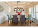 Formal dining room with stylish light fixture, hardwood floors, and elegant wainscoting at 258 Ridge Reserve Dr, Lake Wylie, SC 29710