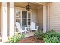 Cozy front porch featuring white columns, two rocking chairs, and lush landscaping at 258 Ridge Reserve Dr, Lake Wylie, SC 29710