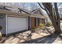 Exterior view of a home with a single-car garage, brick facade, and neatly trimmed bushes, offering practical storage at 3428 Braewick Pl, Charlotte, NC 28227