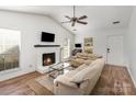 Cozy living area with a painted brick fireplace, wood floors, and comfortable seating, creating a warm ambiance at 3428 Braewick Pl, Charlotte, NC 28227