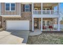 Inviting home featuring a covered porch, balcony, and attached two-car garage at 3619 Martele Dr # 55, Charlotte, NC 28227