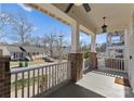 Inviting front porch with brick pillars, white railings, and a ceiling fan, perfect for relaxing at 416 Eli St, Charlotte, NC 28204
