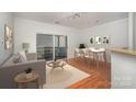 Bright living room features a sliding door to a balcony, table with seating, and wood flooring at 525 N Graham St # 3B, Charlotte, NC 28202