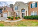 Inviting home exterior featuring a well-kept lawn and garden beds that lead to an arched entryway at 736 Meadow Lake Dr, Matthews, NC 28105