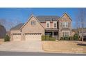 Charming two-story home features a stone and brick facade, a well-manicured lawn, and a spacious three-car garage at 865 Kathy Dianne Dr, Fort Mill, SC 29707