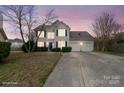 Attractive two-story home with a well-lit exterior, blue shutters, and a convenient two-car garage at 9413 Pastern Ct, Charlotte, NC 28216