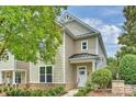 Charming two-story home with light beige siding, a covered porch, and well-maintained landscaping at 12243 Monteith Grove Dr, Huntersville, NC 28078