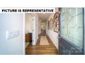 Inviting entryway with wood flooring, decorative wall art, and a stylish front door with glass detailing at 126 Woodhall Way, Troutman, NC 28166