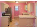 A kitchen with a refrigerator, oven, sink, white cabinets and pink walls at 1660 Ashridge Rd, Rock Hill, SC 29730