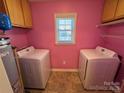 This laundry room features dual washing machines, pink walls and a window at 1660 Ashridge Rd, Rock Hill, SC 29730