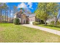 Charming brick two-story home with a well-manicured lawn and a long driveway leading up to the garage at 171 Longboat Rd, Mooresville, NC 28117