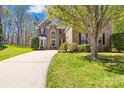 Charming brick two-story home with a well-manicured lawn and a long driveway leading up to the garage at 171 Longboat Rd, Mooresville, NC 28117