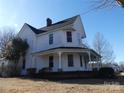 Side view of a charming two-story home with a wrap-around porch and well-maintained yard at 201 W Rice St, Landis, NC 28088