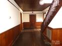 Inviting foyer featuring hardwood floors, wood-paneled walls, and a classic staircase at 201 W Rice St, Landis, NC 28088