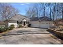 Charming single-story home with a large driveway and a two-car garage, surrounded by mature landscaping at 213 Patternote Rd, Mooresville, NC 28117