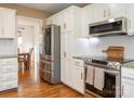 Updated kitchen featuring stainless steel appliances, white cabinets, granite countertops, and hardwood floors at 2520 Foxworth Dr, Monroe, NC 28110