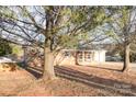 An angle view of a single-story brick home with front-facing garage on a tree-covered lot at 2888 Robinson Rd, Newton, NC 28658