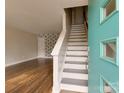 Inviting entryway featuring stairs, wood floors, and a uniquely decorated door at 307 French St, Charlotte, NC 28216