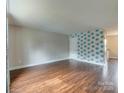 Open-concept living room featuring wood flooring, decorative wall, and neutral paint at 307 French St, Charlotte, NC 28216
