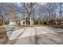 Spacious front yard with a long driveway, mature trees, and well-maintained lawn at 3929 Fernleaf Ct, Charlotte, NC 28215