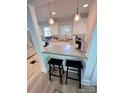 Eat-in kitchen featuring white cabinets, modern lighting, and stainless steel appliances at 4317 Ruskin Dr, Charlotte, NC 28209