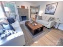 Open-concept living room with modern decor, a striking fireplace, and hardwood floors throughout at 4317 Ruskin Dr, Charlotte, NC 28209