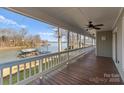 Spacious covered deck with serene lake views, ceiling fan, and ample space for outdoor relaxation at 5153 Glenwood St, Sherrills Ford, NC 28673