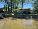 Charming home exterior with a sprawling lawn, retaining wall, and lake access at 5153 Glenwood St, Sherrills Ford, NC 28673