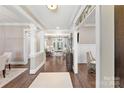 Elegant foyer with hardwood floors, decorative columns, and a view into the spacious living area at 8002 Pemswood St, Charlotte, NC 28277
