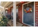 Inviting front entrance with brick facade, decorative wreath, and covered porch with seating at 915 Tj Dr, Monroe, NC 28112