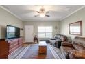 Cozy living room featuring hardwood floors, a ceiling fan, and ample natural light at 915 Tj Dr, Monroe, NC 28112