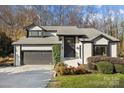 Well-maintained gray brick home with a two-car garage, black trim, mature landscaping and well-maintained lawn at 9334 Hunting Ct, Matthews, NC 28105