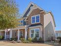 Two-story home with stone and siding, featuring a covered front porch and manicured lawn at 9611 Rayneridge Dr, Huntersville, NC 28078
