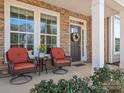 Inviting front porch with seating, plants, and a wreath on the front door of this stunning home at 9611 Rayneridge Dr, Huntersville, NC 28078