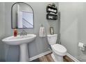 Powder room featuring pedestal sink, decorative mirror and shelving, and neutral wall color at 109 Watrous Way, Mooresville, NC 28115