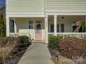 Inviting front porch featuring a pink front door with a wreath and manicured landscaping at 1538 Riverwalk Pkwy, Rock Hill, SC 29730