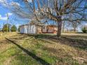 Exterior view showcasing the tranquil backyard, mature trees, and a charming outdoor living space at 2100 Lincolnton Hwy, Cherryville, NC 28021