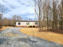 Inviting single-story home with gravel driveway and a natural wood deck, nestled among trees at 2950 Old Cliffside Rd, Shelby, NC 28152