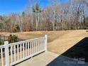 Expansive backyard featuring a tree-lined view, a black fence and a white porch railing at 3309 Juneberry Pl, Indian Land, SC 29707