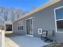 Concrete patio outside a house with gray siding, sliding doors and a view of trees in the background at 3309 Juneberry Pl, Indian Land, SC 29707