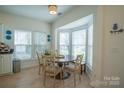 Eat-in kitchen featuring a round wood table with seating and a bay window at 4022 Carl Parmer Dr, Harrisburg, NC 28075
