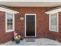 Charming red brick entry with black door, bay windows, and potted plants at 405 Wilson N St, Rock Hill, SC 29730
