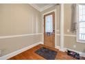 Entryway featuring hardwood floors, decorative molding, and a stylish wooden door at 4103 Belle Meade Cir, Belmont, NC 28012