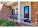 Inviting front porch featuring brick accents and rocking chairs for relaxing outdoors at 4103 Belle Meade Cir, Belmont, NC 28012