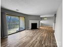 Spacious living room with fireplace, sliding glass door to balcony, and hard surface floors at 4824 Spring Lake Dr # E, Charlotte, NC 28212